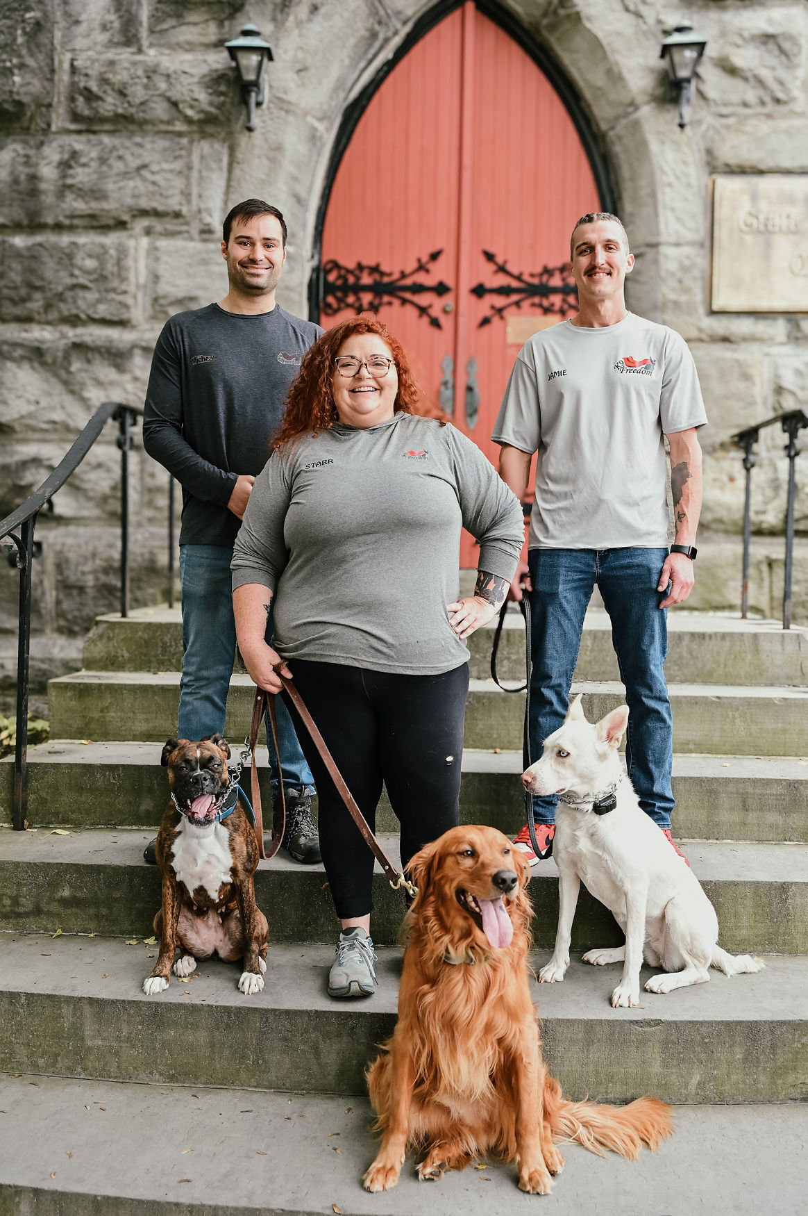 K9 Freedom team with dogs on steps